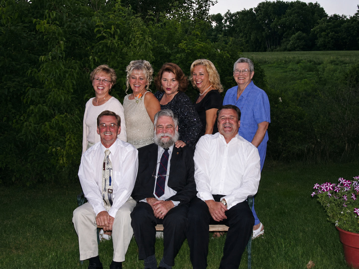 The Jacobson family gathered together in a garden, eight members posed for a group portrait